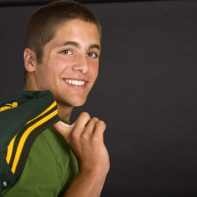 Handsome,Young,Man,With,An,Athletic,Letterman,Jacket,Slung,Over