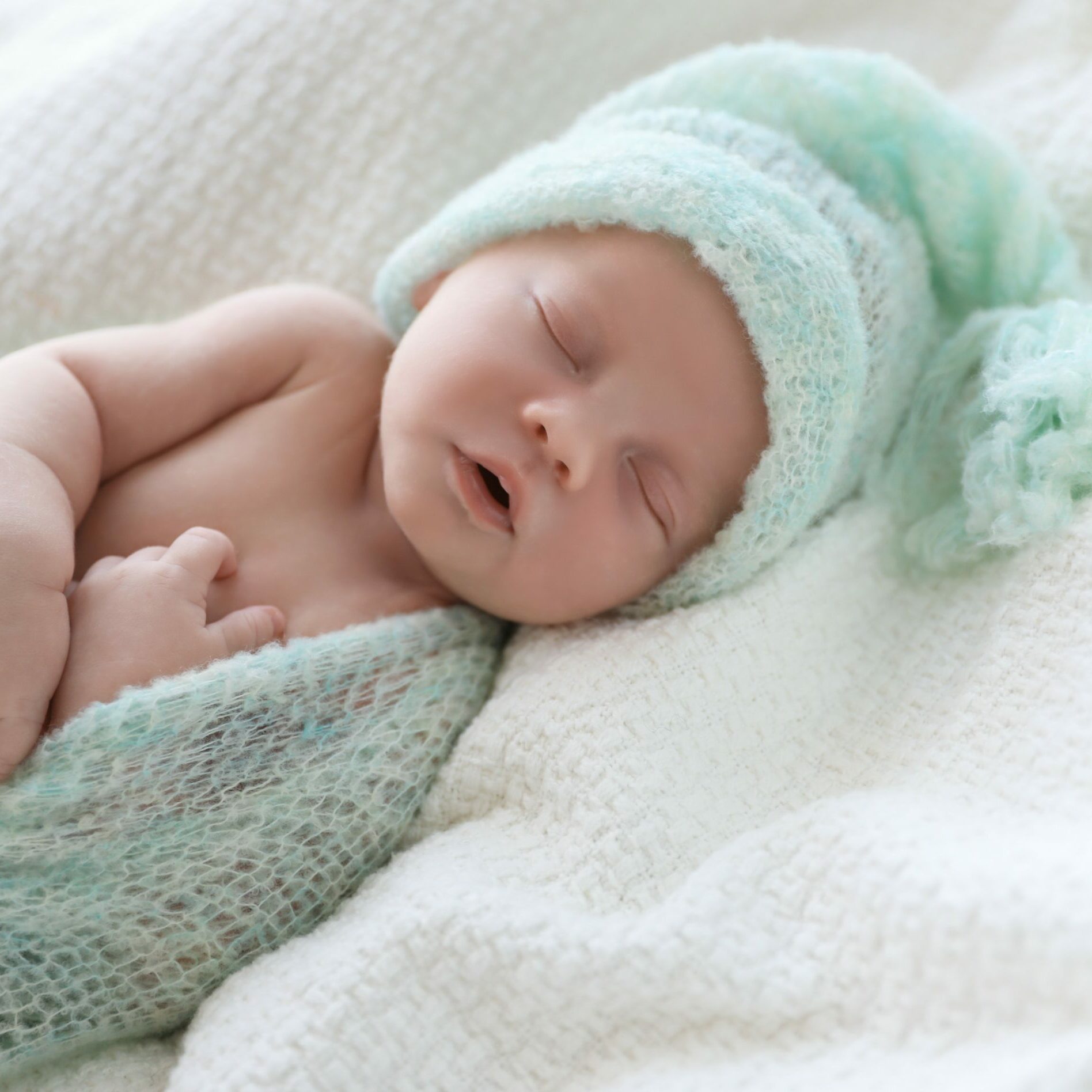 Cute,Newborn,Baby,In,Warm,Hat,Sleeping,On,White,Plaid